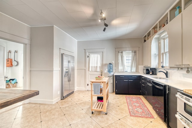 kitchen with light countertops, light tile patterned flooring, dark cabinets, and stainless steel appliances