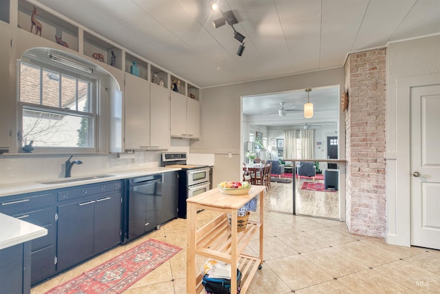 kitchen with blue cabinetry, range with two ovens, a sink, light countertops, and dishwasher