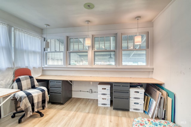 office area with built in desk and light wood finished floors