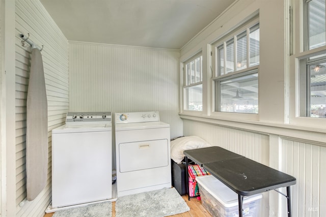 laundry area with laundry area, washing machine and dryer, and wood finished floors