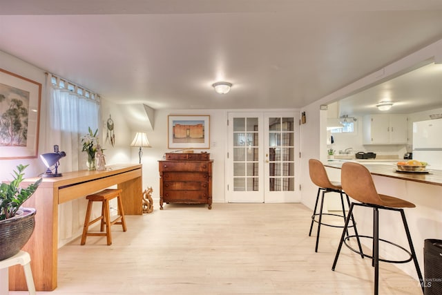 dining room featuring french doors and light wood-style flooring