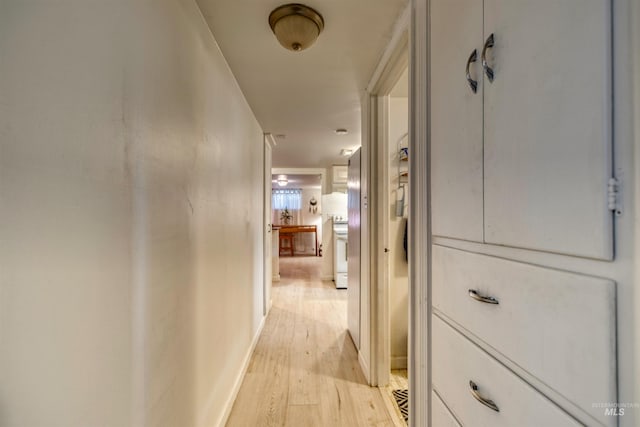 hall featuring light wood-style floors and baseboards