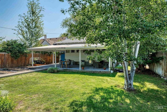 rear view of property with a lawn, a patio, and a fenced backyard