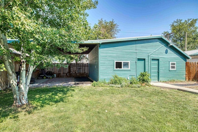 exterior space featuring a patio area, a front lawn, and fence