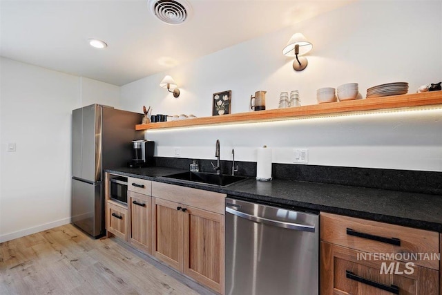 2672 E 4000 N, Twin Falls, ID 83301 - kitchen featuring appliances with stainless steel finishes, a sink, open shelves, light wood finished floors, and dark countertops