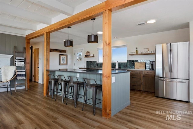 2672 E 4000 N, Twin Falls, ID 83301 - kitchen featuring freestanding refrigerator, wood finished floors, beamed ceiling, dark countertops, and a breakfast bar area