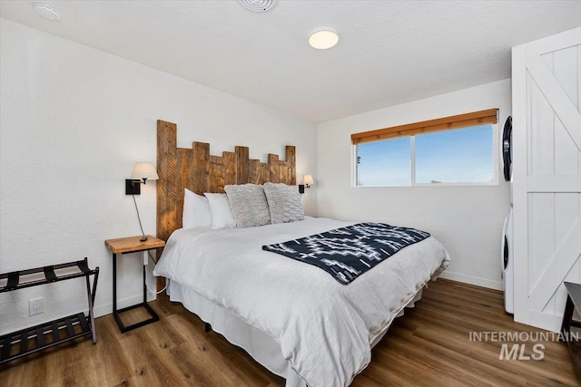 2672 E 4000 N, Twin Falls, ID 83301 - bedroom featuring stacked washing machine and dryer, baseboards, and wood finished floors