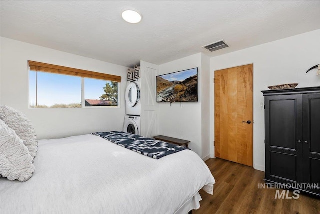 2672 E 4000 N, Twin Falls, ID 83301 - bedroom featuring stacked washer / drying machine, dark wood-type flooring, and baseboards