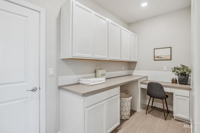 office area featuring built in desk and light hardwood / wood-style flooring