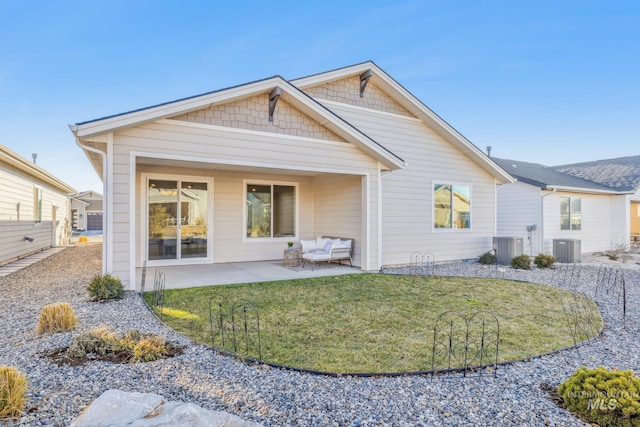 rear view of property featuring an outdoor hangout area, central air condition unit, a patio area, and a yard