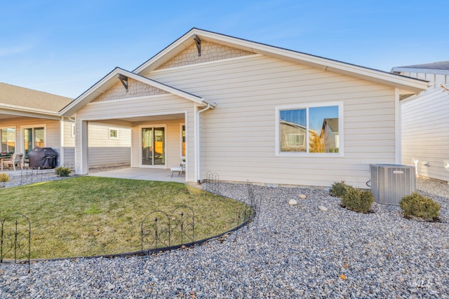 rear view of property with a lawn, central AC, and a patio