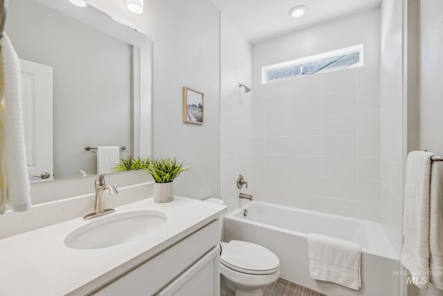 full bathroom featuring toilet, tiled shower / bath, and vanity