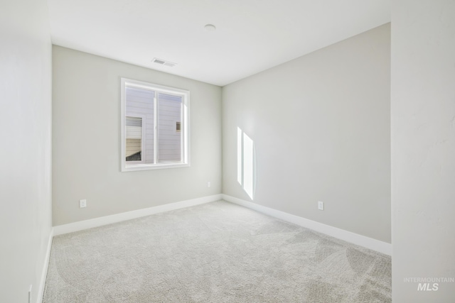 spare room featuring light carpet and plenty of natural light