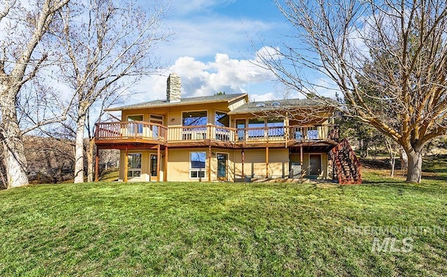 rear view of house featuring a wooden deck and a yard