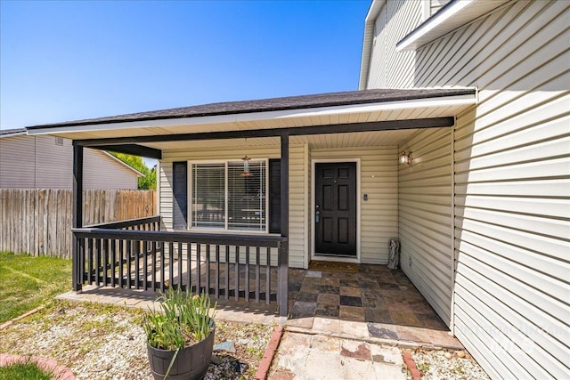 entrance to property featuring fence and covered porch