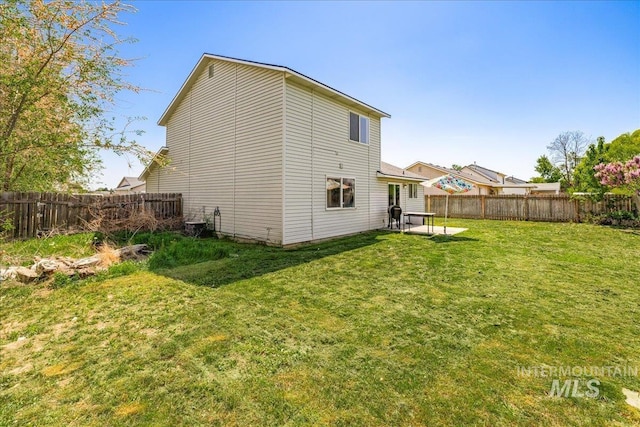 back of property featuring a fenced backyard and a lawn