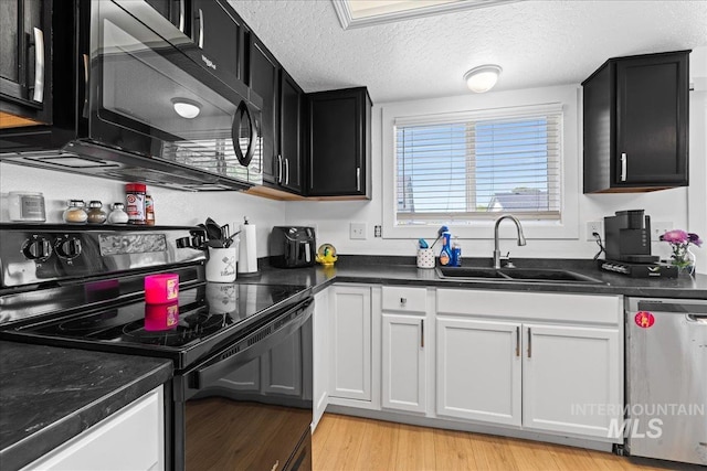 kitchen with a textured ceiling, dark countertops, a sink, black appliances, and dark cabinets
