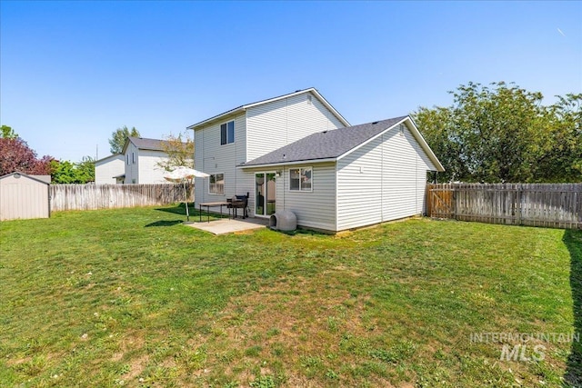 rear view of house with a patio, a fenced backyard, a shed, a lawn, and an outbuilding