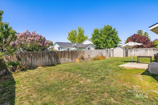 view of yard with an outdoor structure, a fenced backyard, and a storage shed