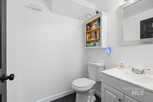 bathroom with toilet, baseboards, and vanity