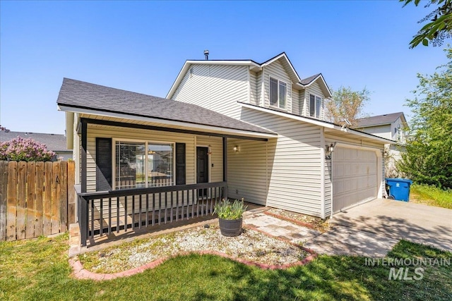 traditional home with an attached garage, fence, covered porch, and concrete driveway
