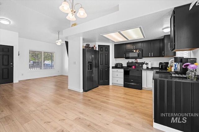 kitchen featuring a sink, dark countertops, black appliances, and light wood finished floors