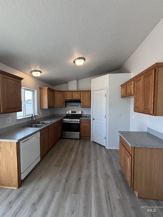 1150 NW 22nd St, Fruitland, ID 83619 - kitchen featuring dishwasher, stainless steel gas range, a textured ceiling, lofted ceiling, and brown cabinets