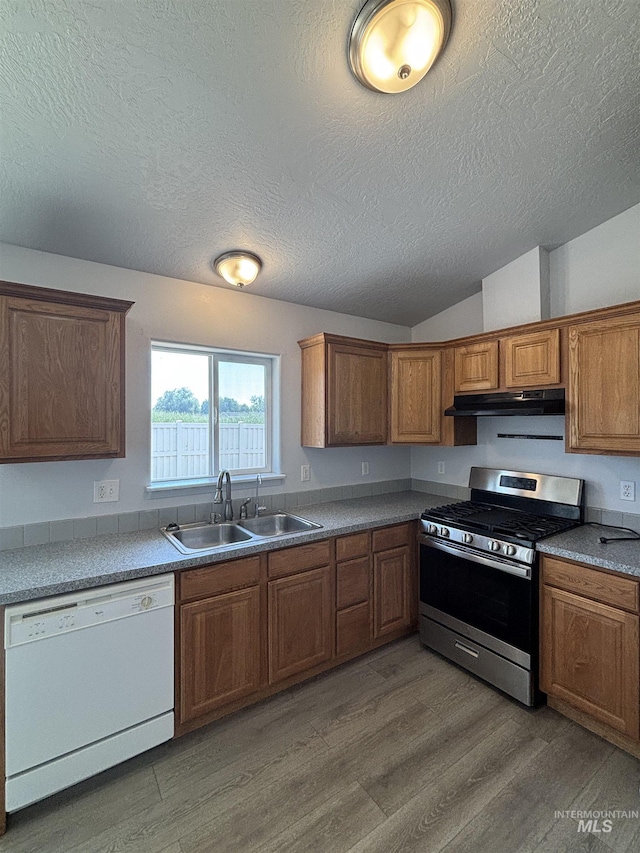 1150 NW 22nd St, Fruitland, ID 83619 - kitchen featuring dishwasher, stainless steel range with gas stovetop, a textured ceiling, light wood-style flooring, and lofted ceiling