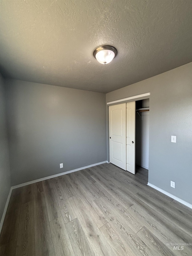 1150 NW 22nd St, Fruitland, ID 83619 - unfurnished bedroom with wood finished floors, a textured ceiling, and a closet
