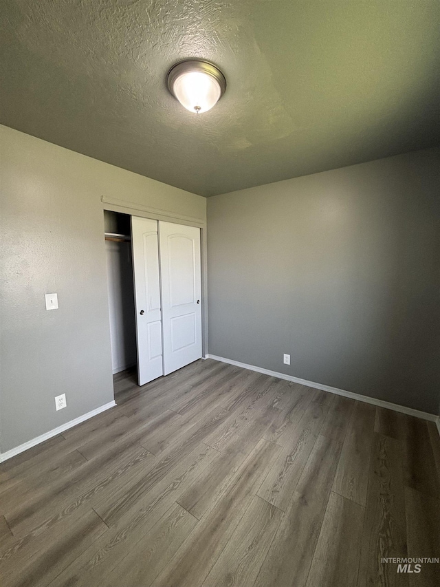1150 NW 22nd St, Fruitland, ID 83619 - unfurnished bedroom featuring wood finished floors, a closet, and a textured ceiling
