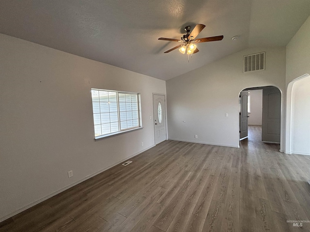 1150 NW 22nd St, Fruitland, ID 83619 - unfurnished room with a ceiling fan, arched walkways, vaulted ceiling, and wood finished floors