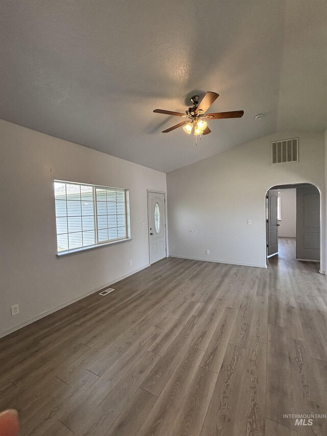 1150 NW 22nd St, Fruitland, ID 83619 - unfurnished living room with ceiling fan, arched walkways, lofted ceiling, and wood finished floors