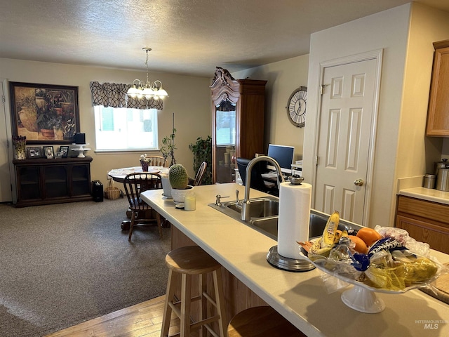 168 Long Is, Twin Falls, ID 83301 - kitchen with a kitchen bar, a sink, light countertops, decorative light fixtures, and a notable chandelier