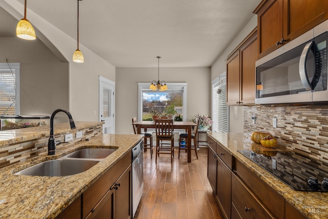 kitchen featuring dark hardwood / wood-style flooring, stainless steel appliances, hanging light fixtures, and sink