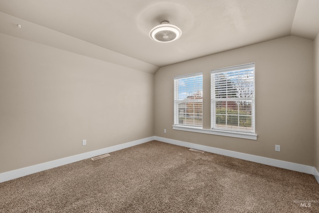 carpeted spare room featuring lofted ceiling