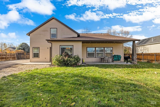 rear view of house featuring a yard and a patio