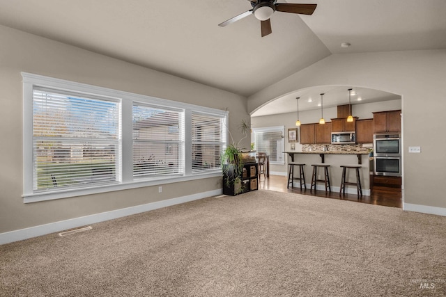 carpeted living room featuring ceiling fan and lofted ceiling