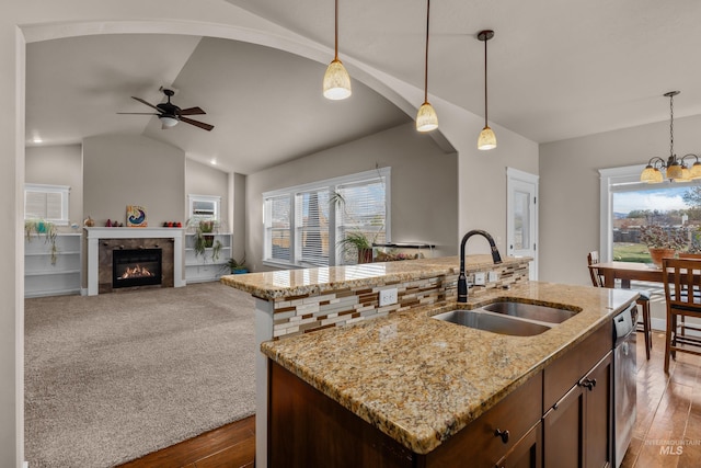 kitchen with hardwood / wood-style floors, lofted ceiling, sink, and an island with sink