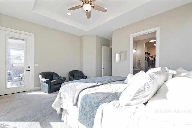 bedroom featuring ceiling fan, carpet flooring, a tray ceiling, and access to outside