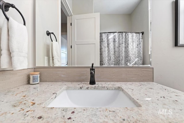 bathroom with vanity and tasteful backsplash