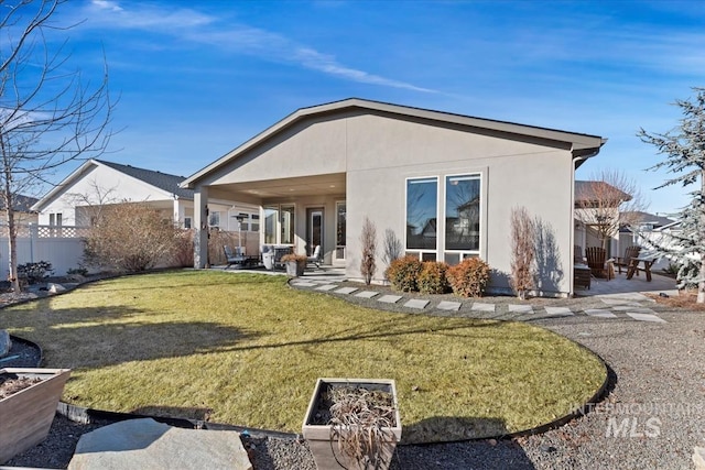 rear view of property featuring a patio area and a lawn