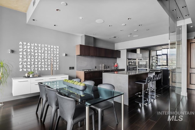 kitchen featuring a kitchen island, white cabinets, dark brown cabinetry, and dark hardwood / wood-style flooring