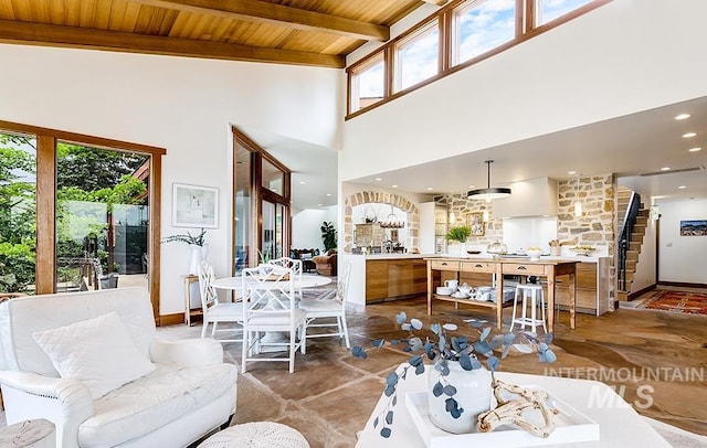 living room featuring a wealth of natural light, beam ceiling, wooden ceiling, and a fireplace