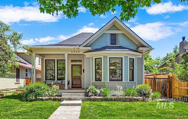 victorian-style house featuring covered porch and roof with shingles
