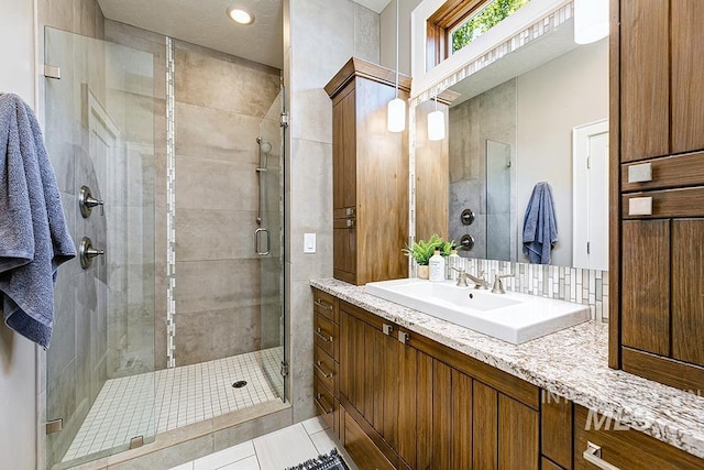 bathroom with a shower stall, vanity, and tile patterned flooring