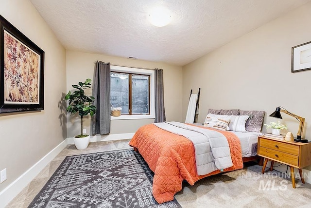carpeted bedroom featuring a textured ceiling and baseboards