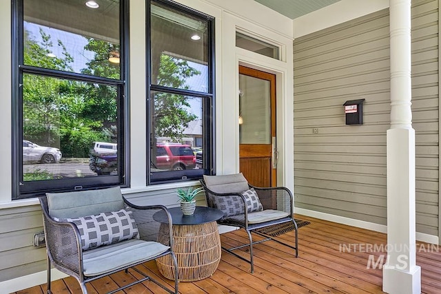 sunroom with hardwood / wood-style floors, wood walls, and baseboards