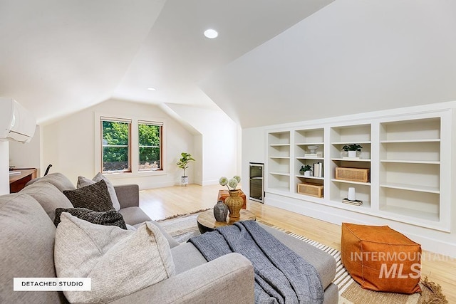 living room featuring a wall mounted AC, wood finished floors, vaulted ceiling, and baseboards