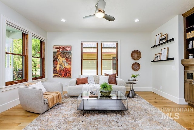 living area with wood finished floors, baseboards, ceiling fan, and recessed lighting