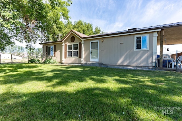 back of house featuring a lawn